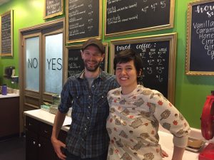 Tommy and Amber standing behind their cafe counter